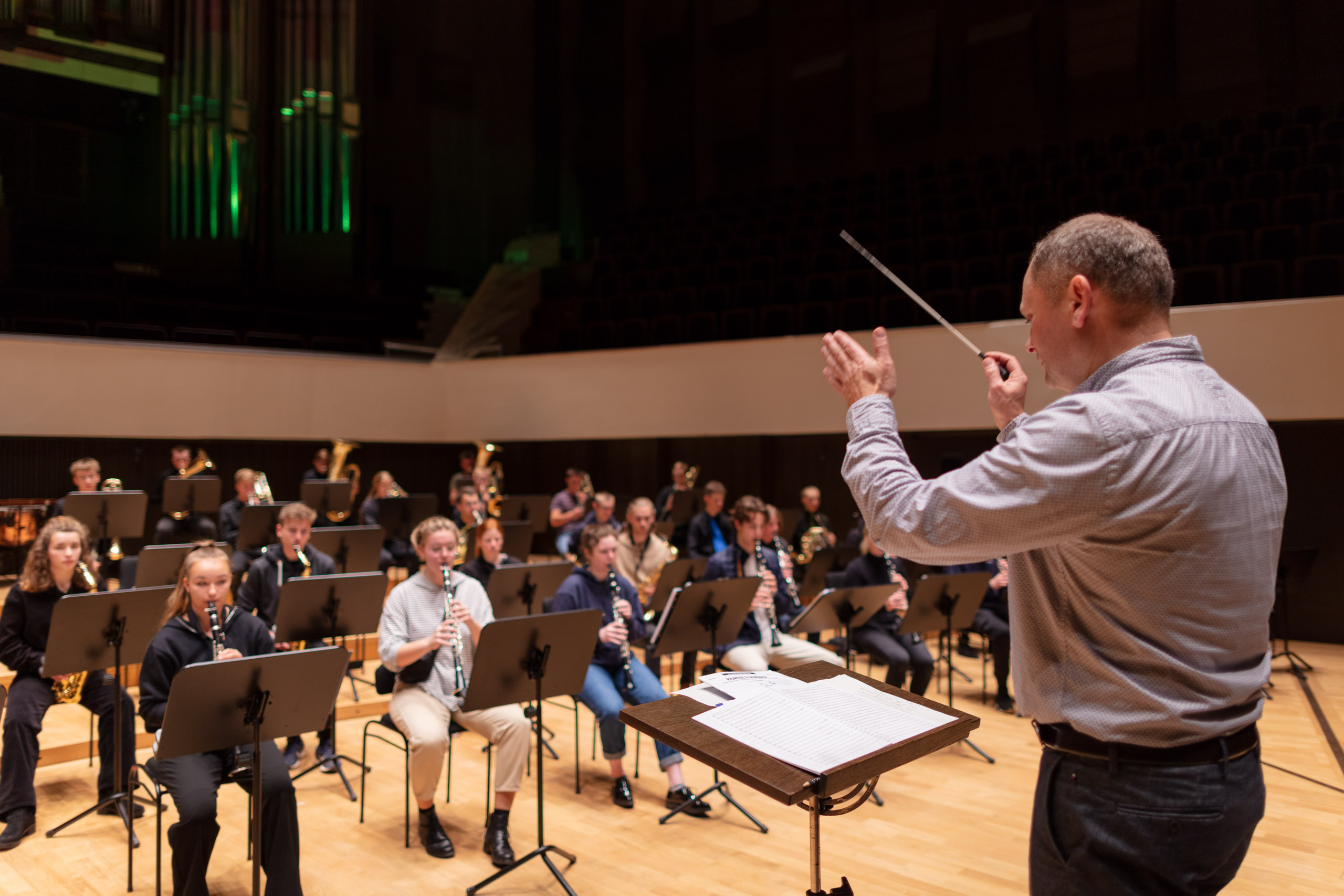 das Sinfonische Blasorchester auf der Bühne im Gewandhaus, der Dirigent Wilfried Thoß im Vordergrund