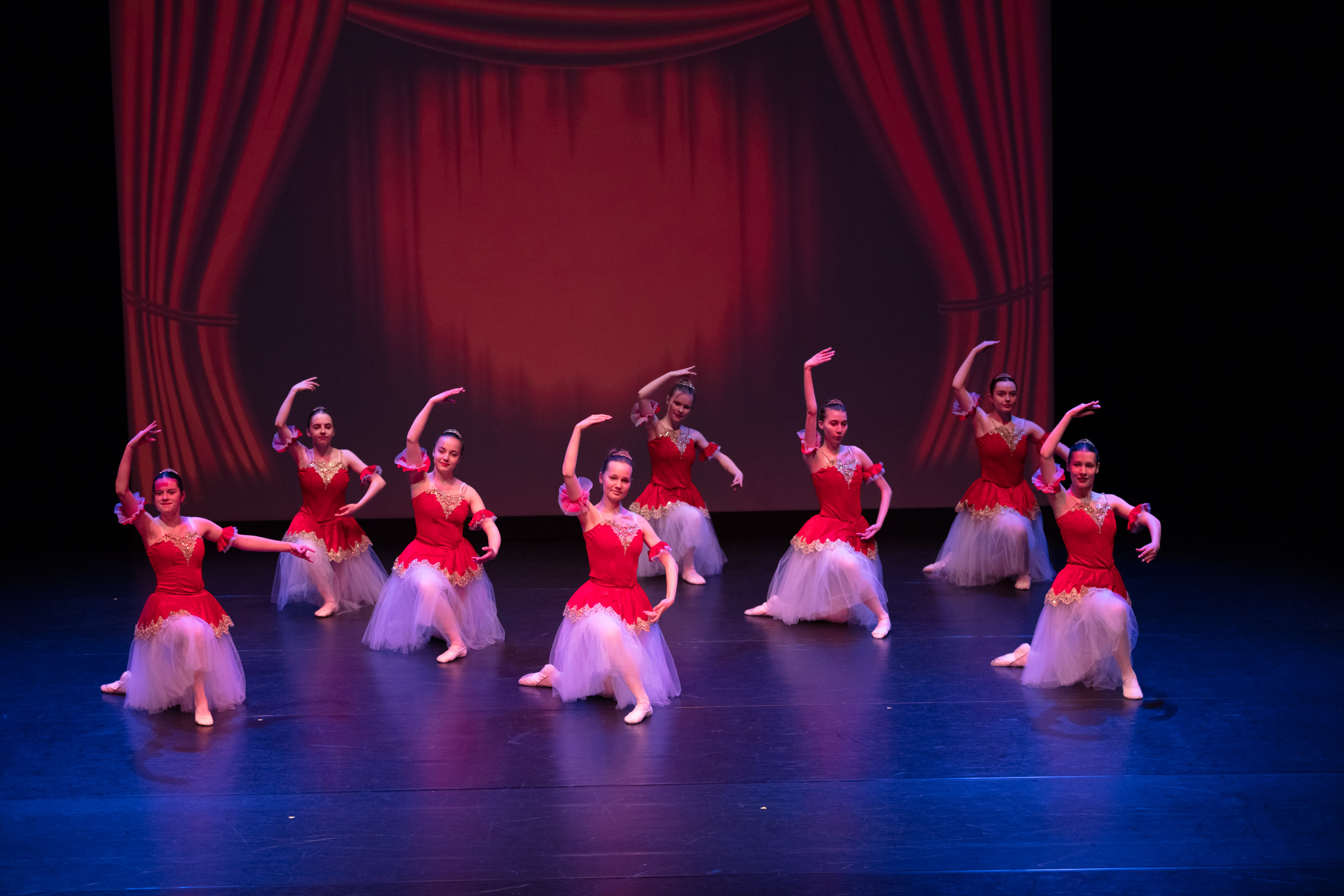 acht Tänzerinnen in rot-weißen Kleidern