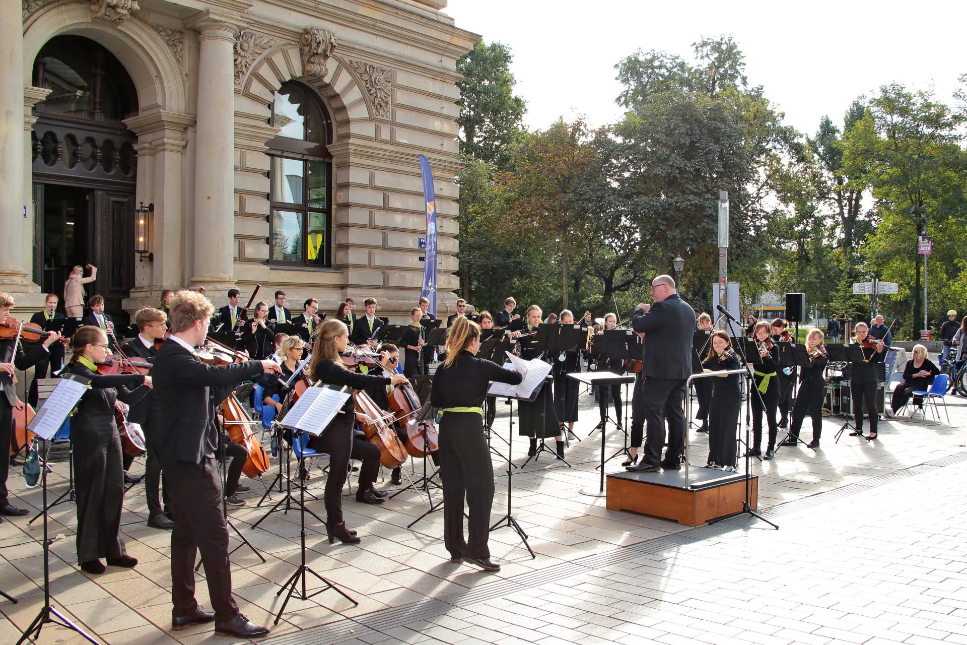 das Jugendsinfonieorchester un der Dirigent Ron-Dirk Entleutner vor der Musikschule beim Musikschulfest