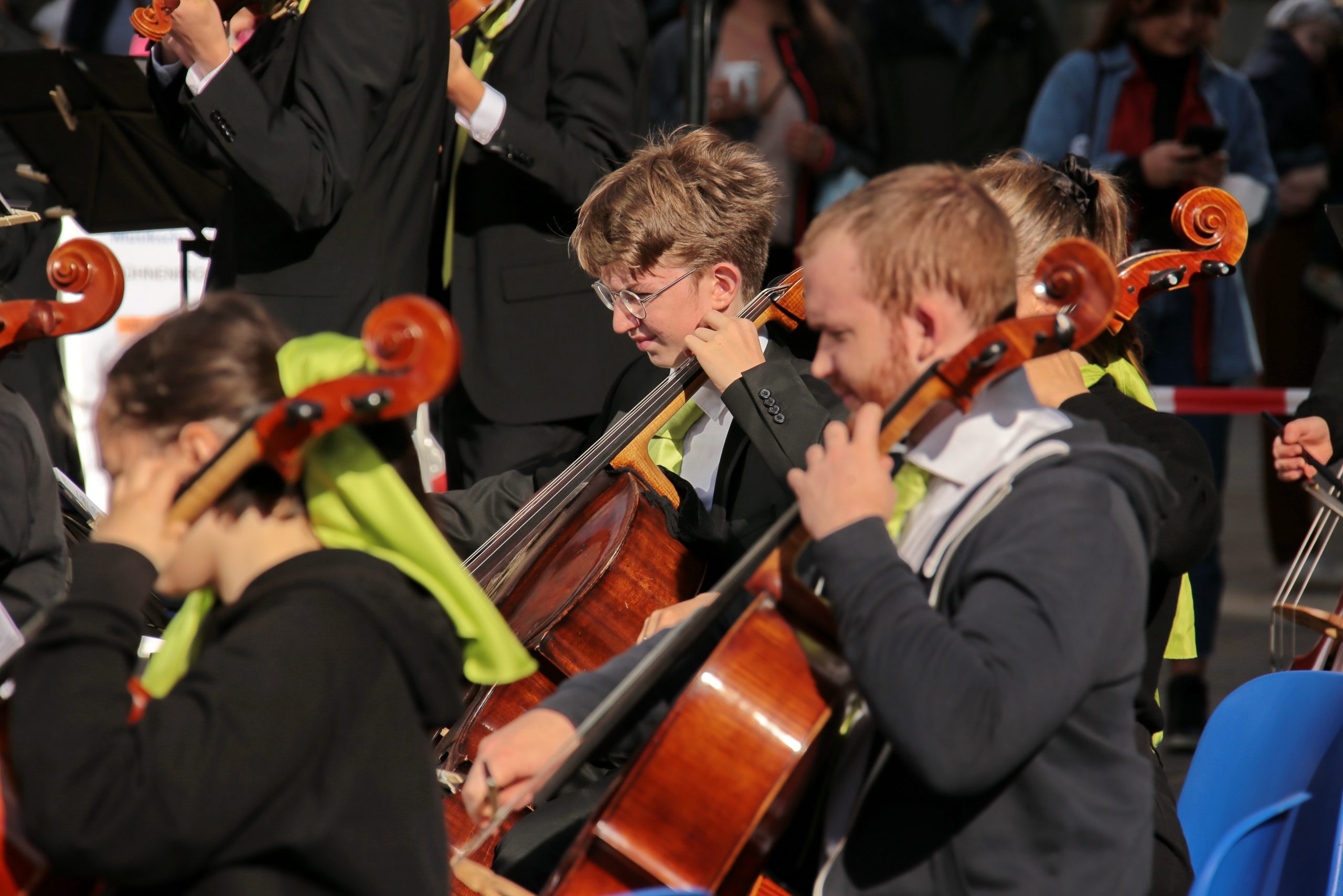 Mitglieder des Jugendsinfonieorchesters, die Cello spielen vor der Musikschule beim Musikschulfest