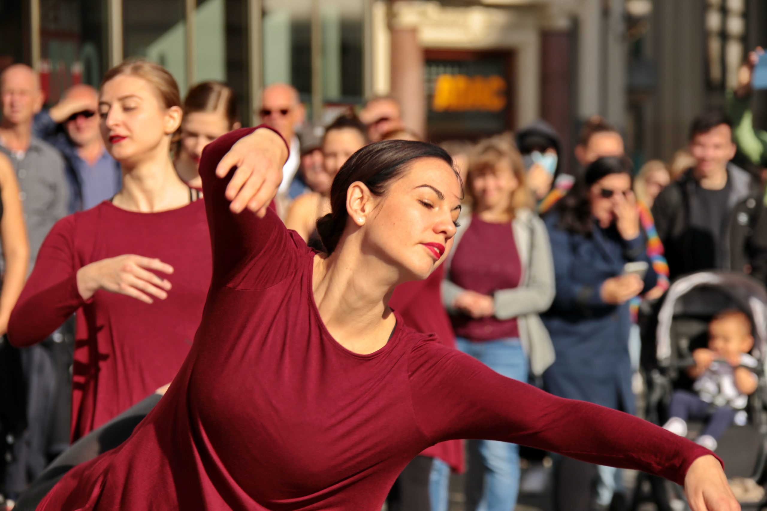 Großaufnahme, Tänzerinnen in rot gekleidet, draußen vor der Musikschule