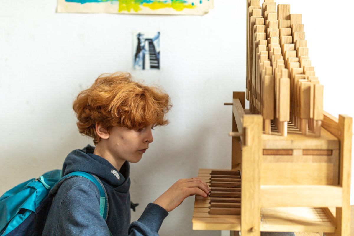 ein Junge probiert die Mini-Orgel aus